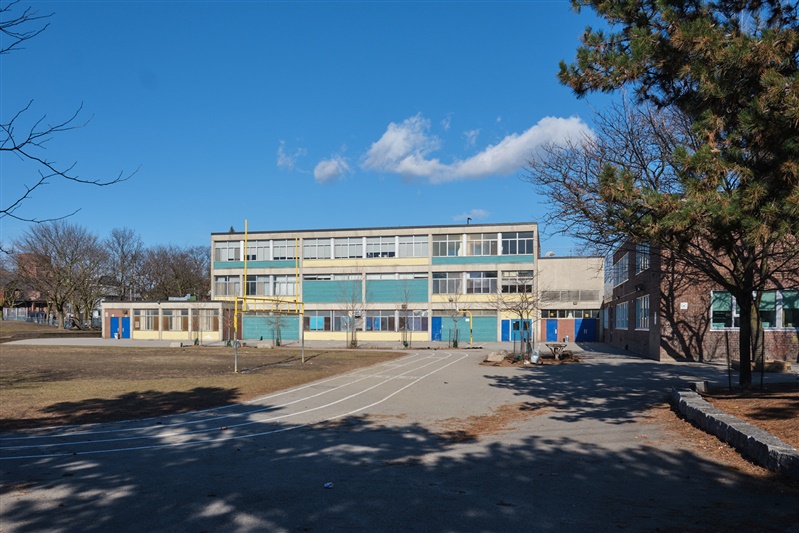 Wide view of the shared schoolyard on a blue-sky day